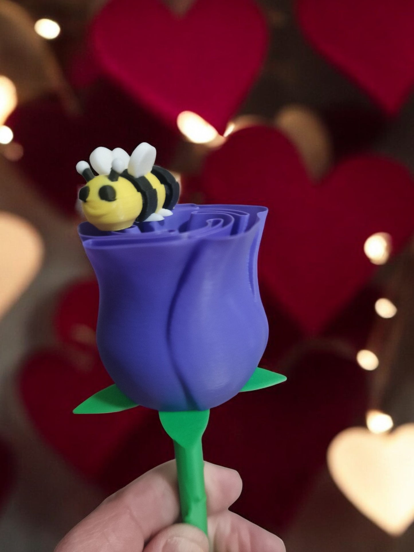 flower pot with red silk rose, two additional roses, two daffodils, love heart pendants reading 'I Love You' and 'Happy Motherās Day', and a cute bee. Dimensions: 28cm (H) x 18cm (W) x 18cm (D). Perfect for Motherās Day or Valentineās Day, a lasting gift that doesnāt wilt.