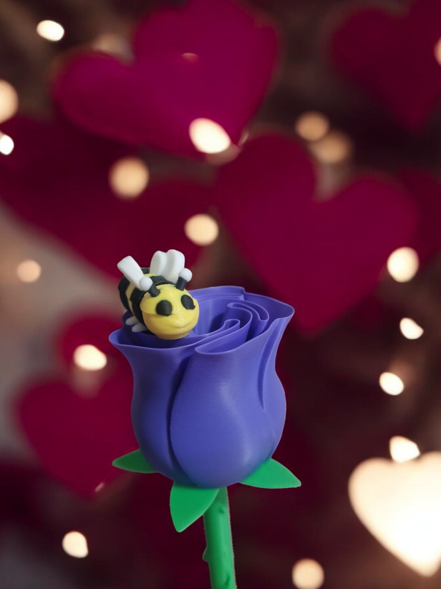 flower pot with red silk rose, two additional roses, two daffodils, love heart pendants reading 'I Love You' and 'Happy Motherās Day', and a cute bee. Dimensions: 28cm (H) x 18cm (W) x 18cm (D). Perfect for Motherās Day or Valentineās Day, a lasting gift that doesnāt wilt.