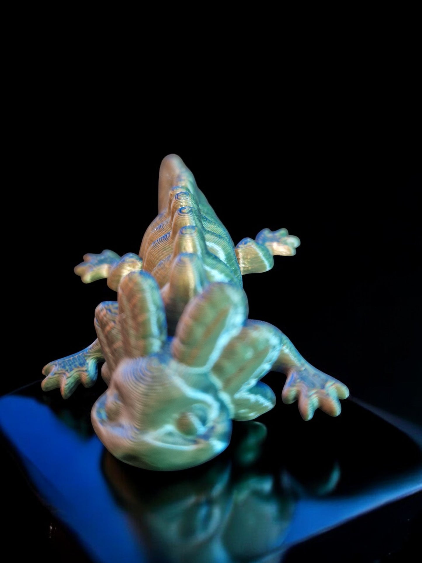 A 3D-printed articulating axolotl figurine with movable limbs and tail, measuring 9cm long, 4cm wide, and 3cm high. This durable, lightweight piece features a random dual-tone color design, making it a playful and unique display item or gift for axolotl enthusiasts and collectors.