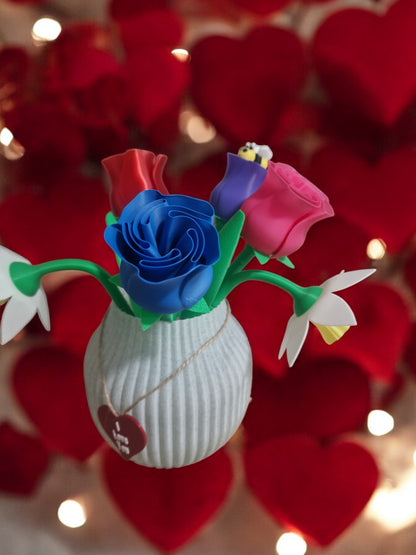 flower pot with red silk rose, two additional roses, two daffodils, love heart pendants reading 'I Love You' and 'Happy Mother’s Day', and a cute bee. Dimensions: 28cm (H) x 18cm (W) x 18cm (D). Perfect for Mother’s Day or Valentine’s Day, a lasting gift that doesn’t wilt.
