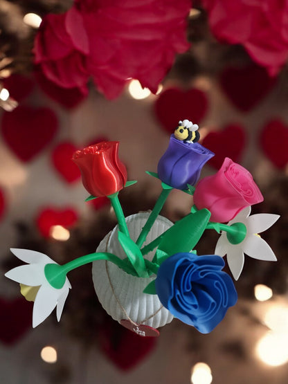flower pot with red silk rose, two additional roses, two daffodils, love heart pendants reading 'I Love You' and 'Happy Mother’s Day', and a cute bee. Dimensions: 28cm (H) x 18cm (W) x 18cm (D). Perfect for Mother’s Day or Valentine’s Day, a lasting gift that doesn’t wilt.