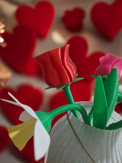 flower pot with red silk rose, two additional roses, two daffodils, love heart pendants reading 'I Love You' and 'Happy Mother’s Day', and a cute bee. Dimensions: 28cm (H) x 18cm (W) x 18cm (D). Perfect for Mother’s Day or Valentine’s Day, a lasting gift that doesn’t wilt.