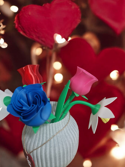 flower pot with red silk rose, two additional roses, two daffodils, love heart pendants reading 'I Love You' and 'Happy Mother’s Day', and a cute bee. Dimensions: 28cm (H) x 18cm (W) x 18cm (D). Perfect for Mother’s Day or Valentine’s Day, a lasting gift that doesn’t wilt.